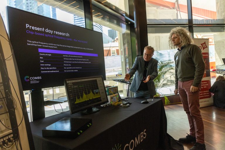 A scientist stands at a table giving a presentation